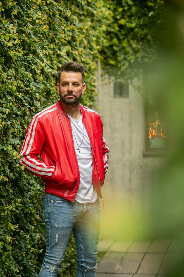 Roma red leather jacket outdoor full-body shot, male model against ivy wall, silver stripe bomber