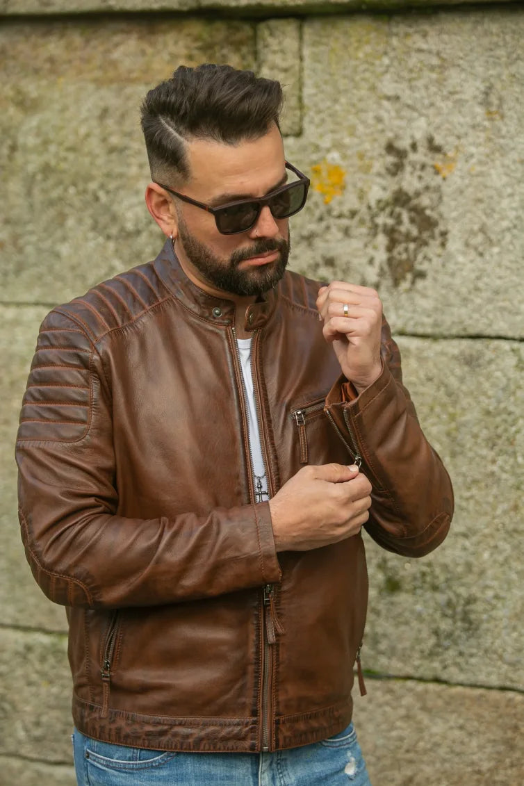 Madrid cognac leather jacket front three-quarter view on male model adjusting zip, outdoor setting