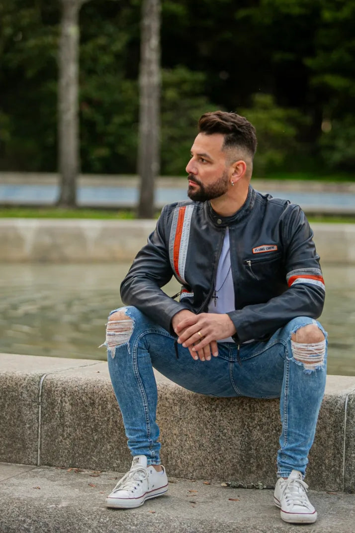 New York black leather jacket male model seated outdoors, full-body front view, orange stripe detail