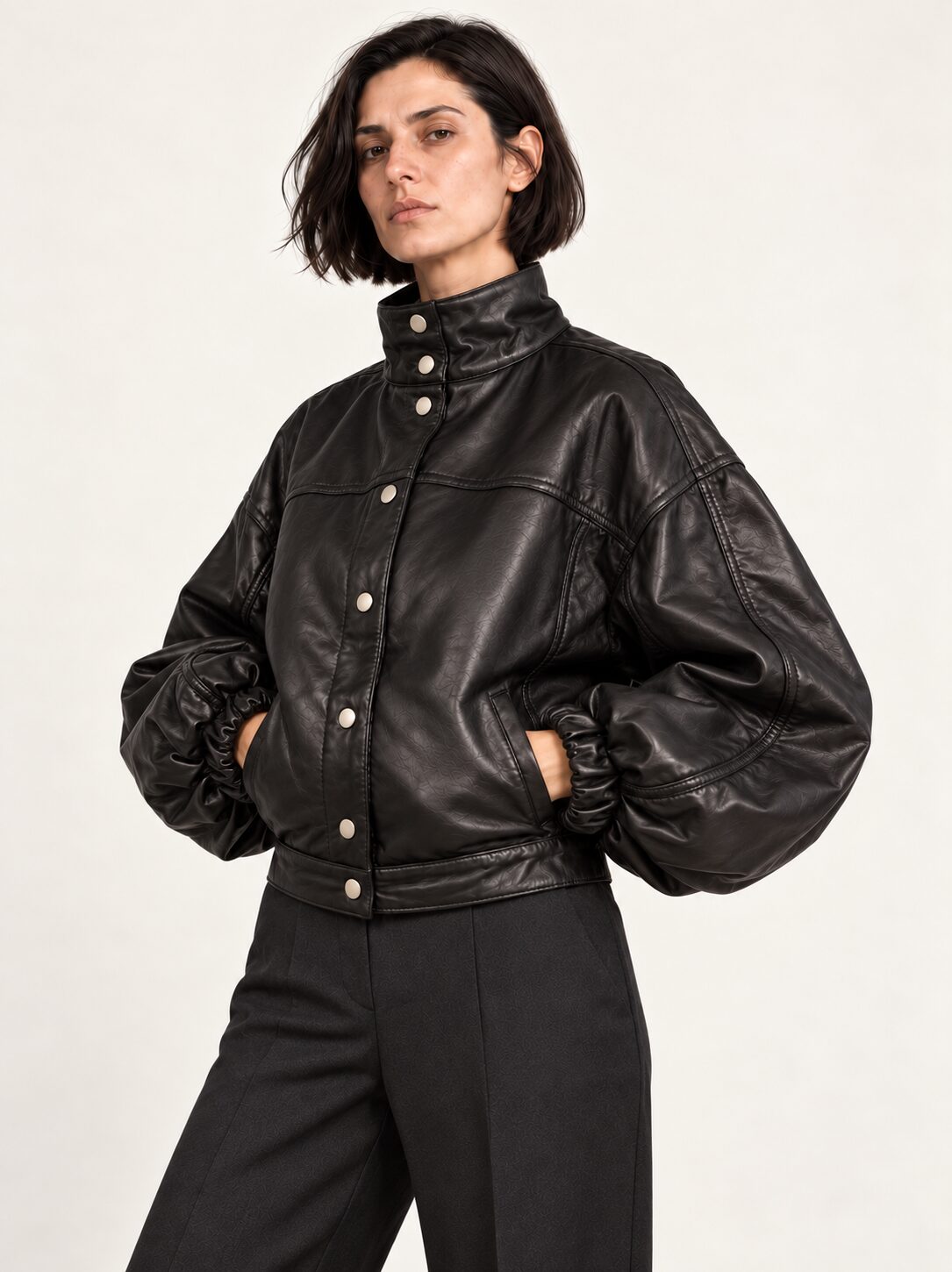 Woman wearing the Electra black leather jacket with puff sleeves, three-quarter view