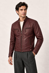 Three-quarter view of a man wearing the Tifrano Prague burgundy leather jacket with quilted shoulders and zipped pockets.