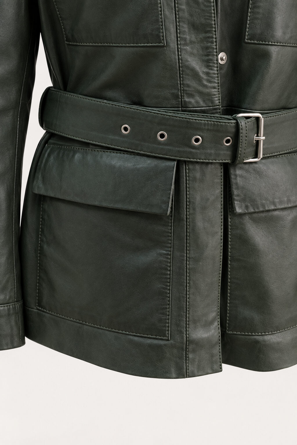Close-up of the Sofia forest green leather jacket, showing belt, pockets and leather texture