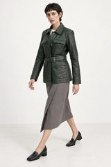 Woman wearing the Sofia forest green leather jacket in an editorial full-body pose