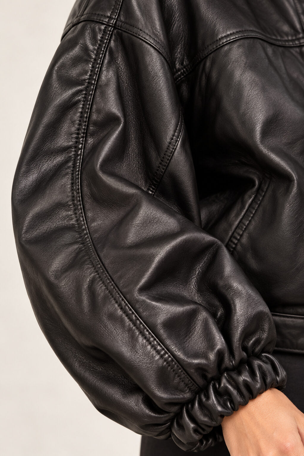 Close-up detail of the Electra black leather jacket with puff sleeves