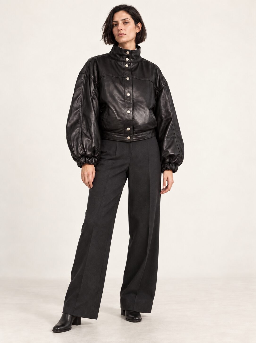 Woman wearing the Electra black leather jacket with puff sleeves, full-body front view