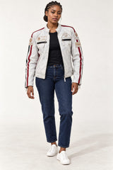 Full-body front view of a woman wearing the Tifrano MB dirty white leather biker jacket with jeans and white sneakers