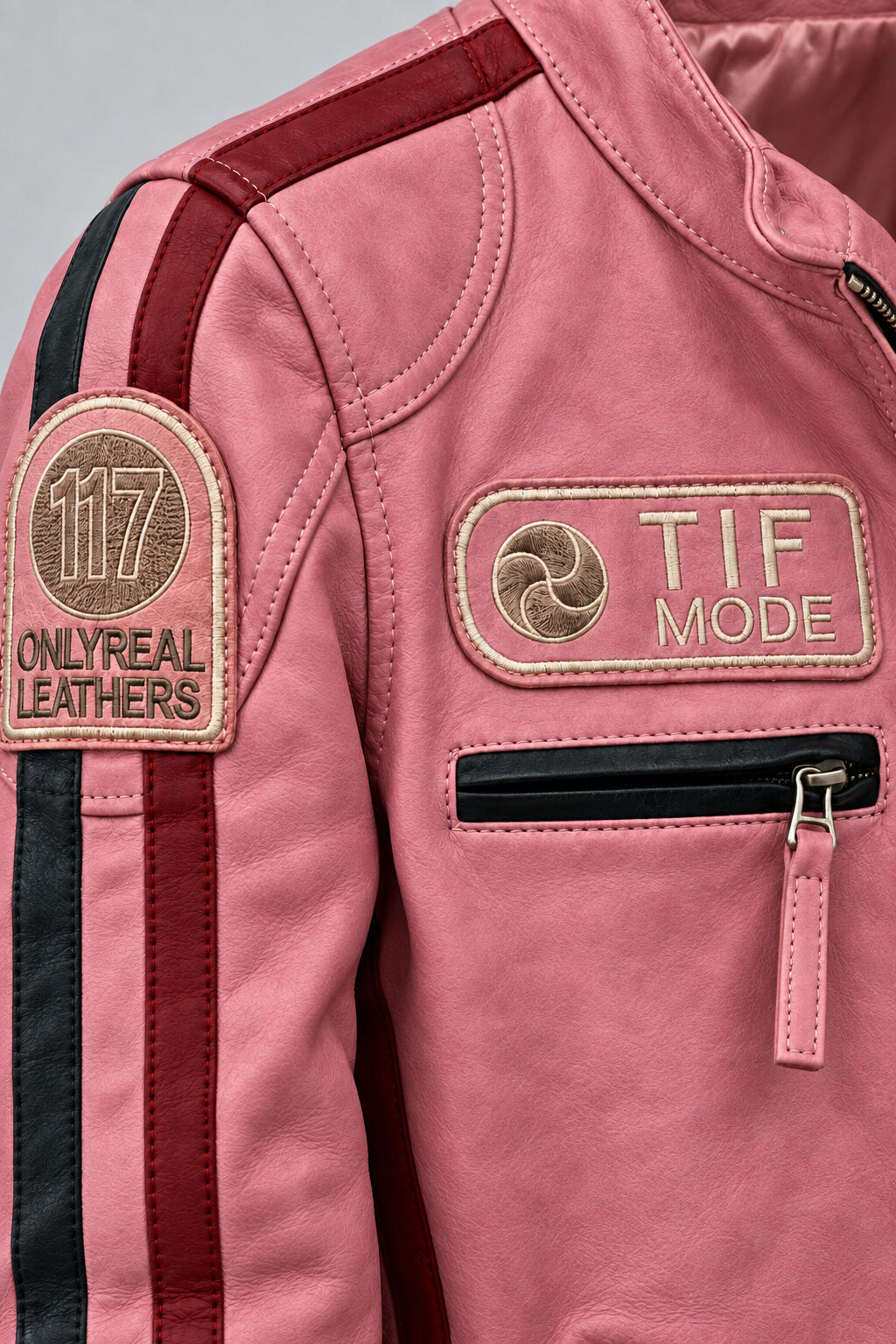 Close-up detail of the pink leather biker jacket with patches