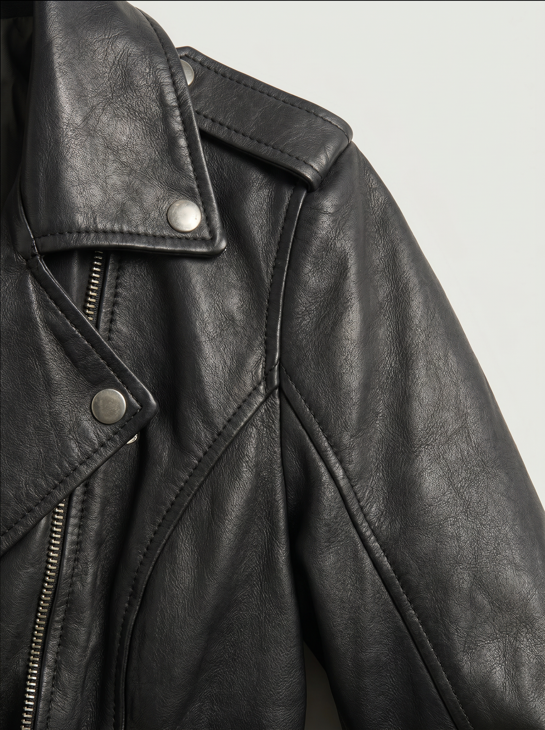 Close-up of the Montreal black leather biker jacket - sheep leather texture, snap collar and shoulder epaulette
